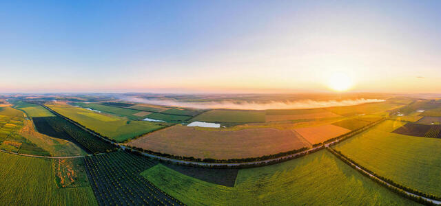 aerial-drone-panorama-view-nature-moldova-sunset-smoke-from-fire-wide-fields-road-sun